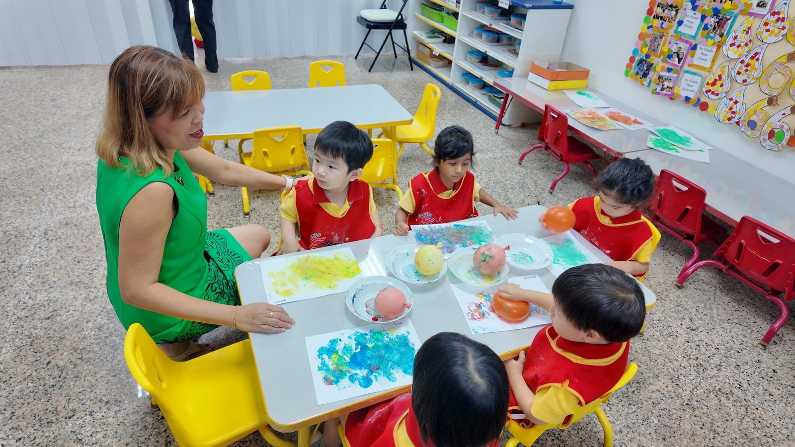 Teacher supervising balloon painting